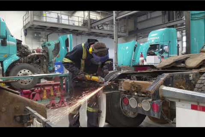 Mechanic using a vibrating tool on a semi truck