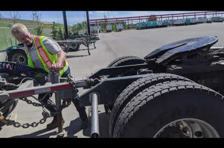 truck driver attaching a trailer to the truck