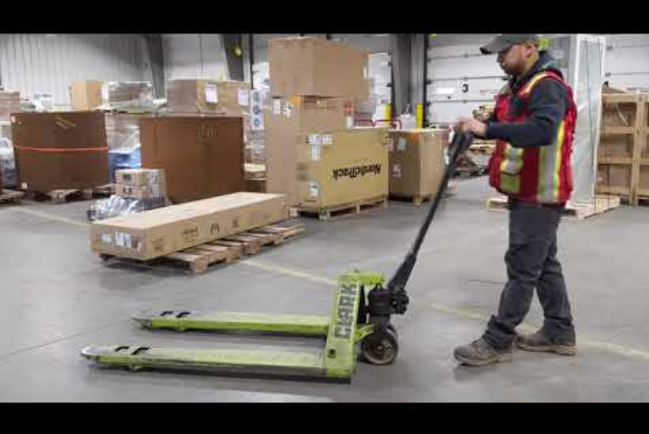warehouse employee pushing a pallet jack