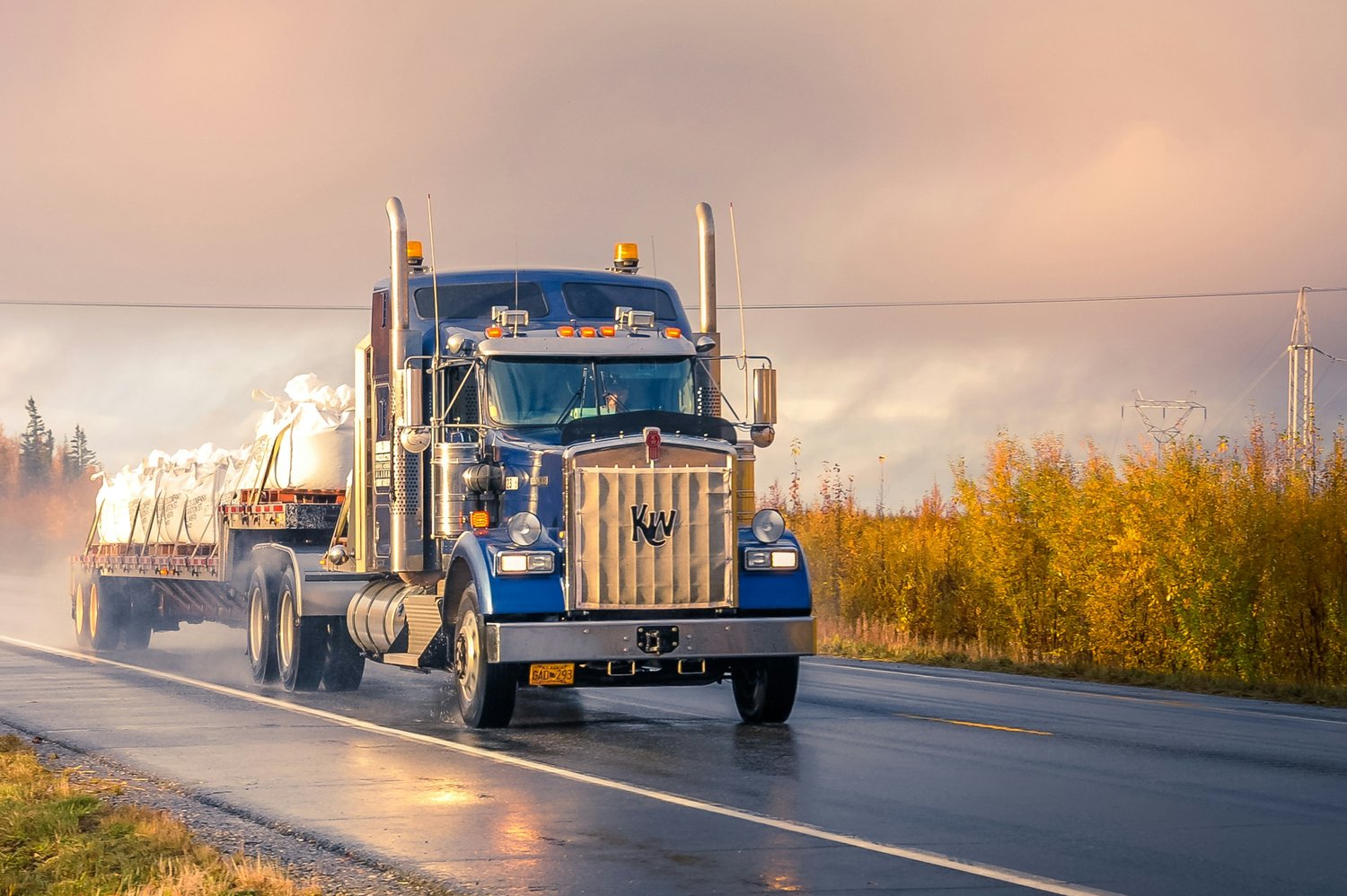 Semi truck driving down a wet highway Semi truck driving down a wet highway