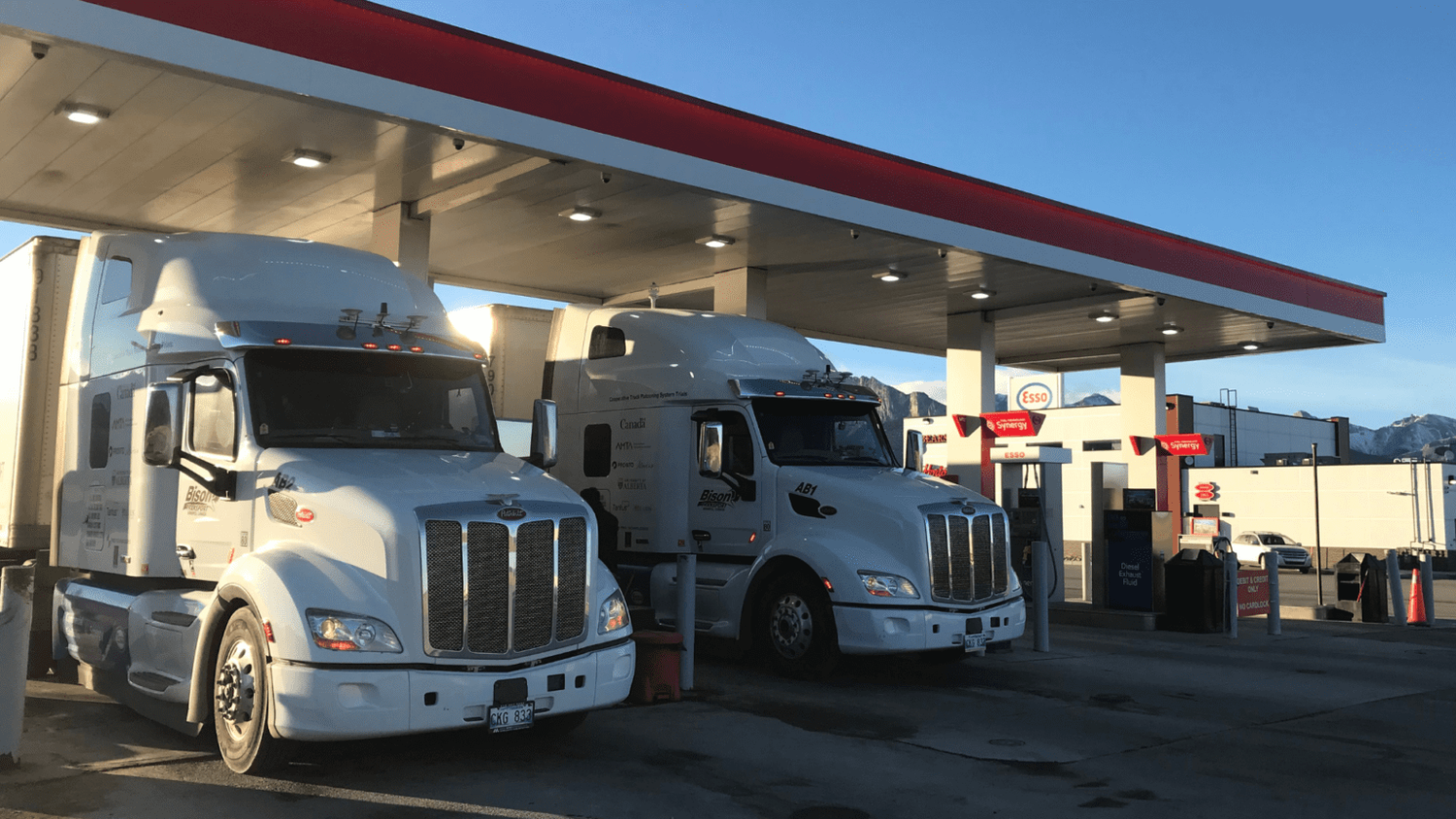 Bison Transport trucks parked at an Esso gas station